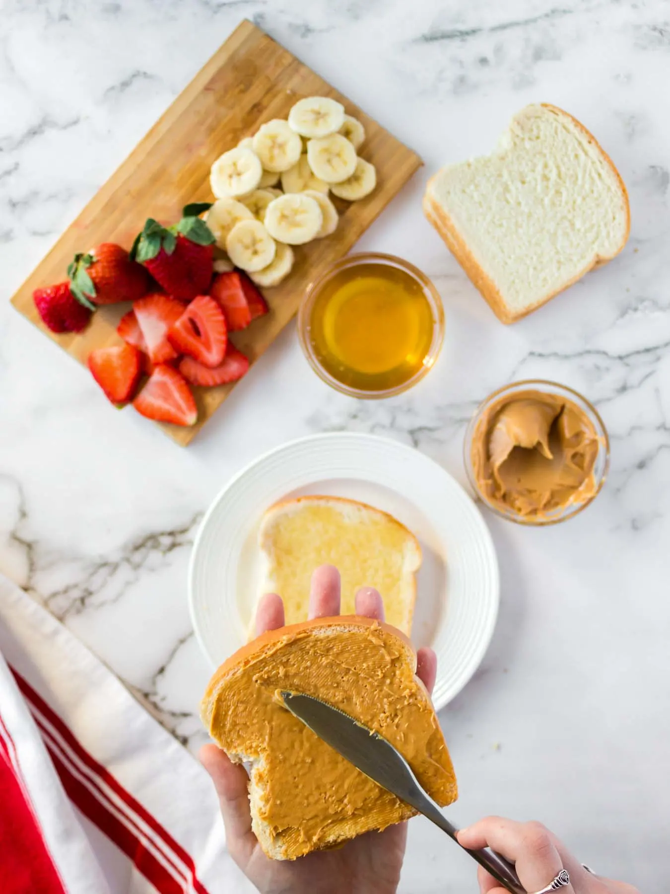 Spreading peanut butter on bread.