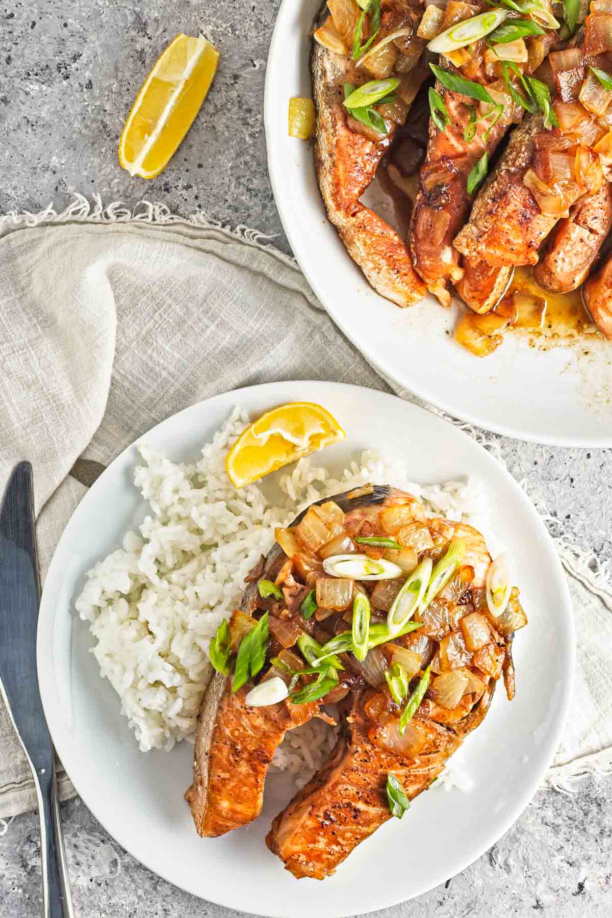 Plates of rice with pan-fried salmon steaks.