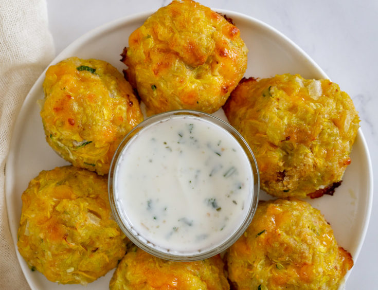 yellow squash tots with yogurt dip on a plate