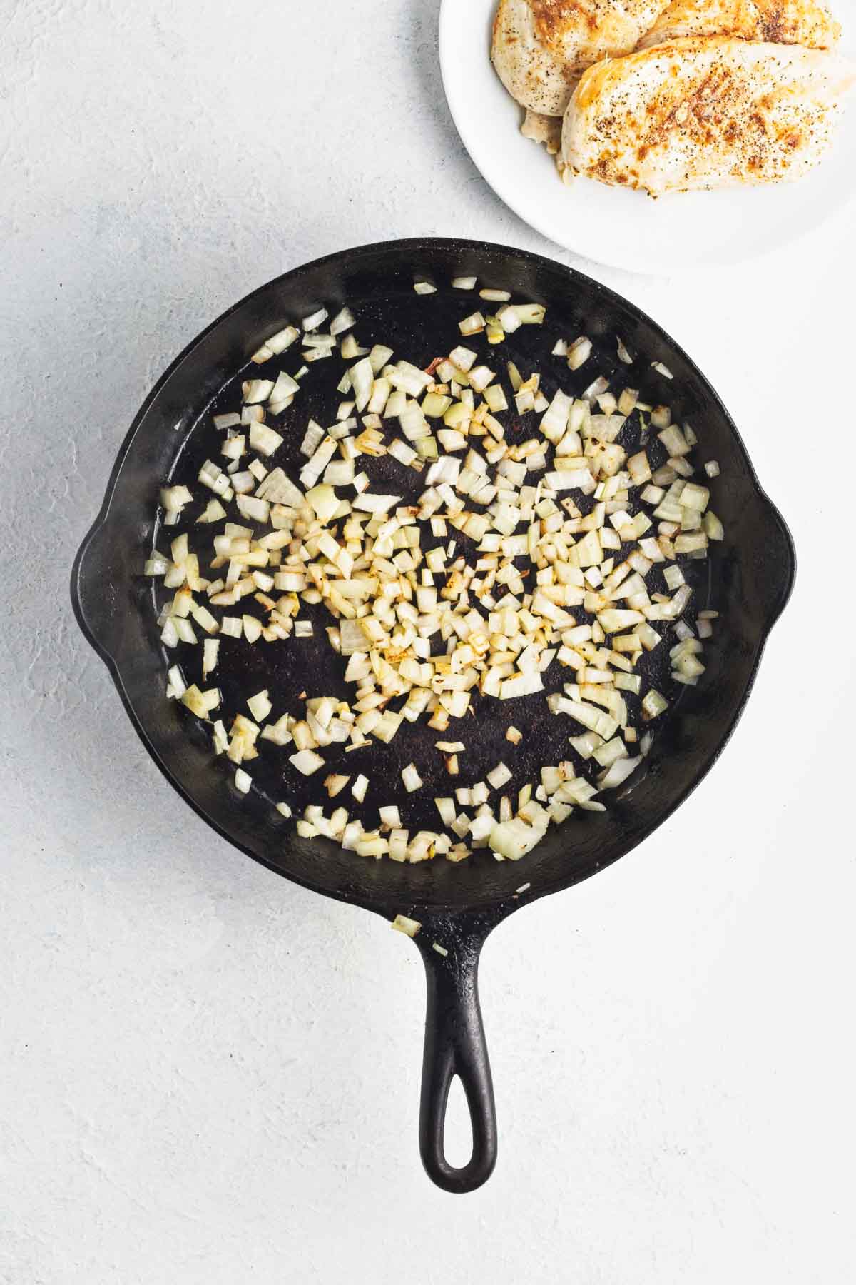 Diced onions sautéing in a skillet