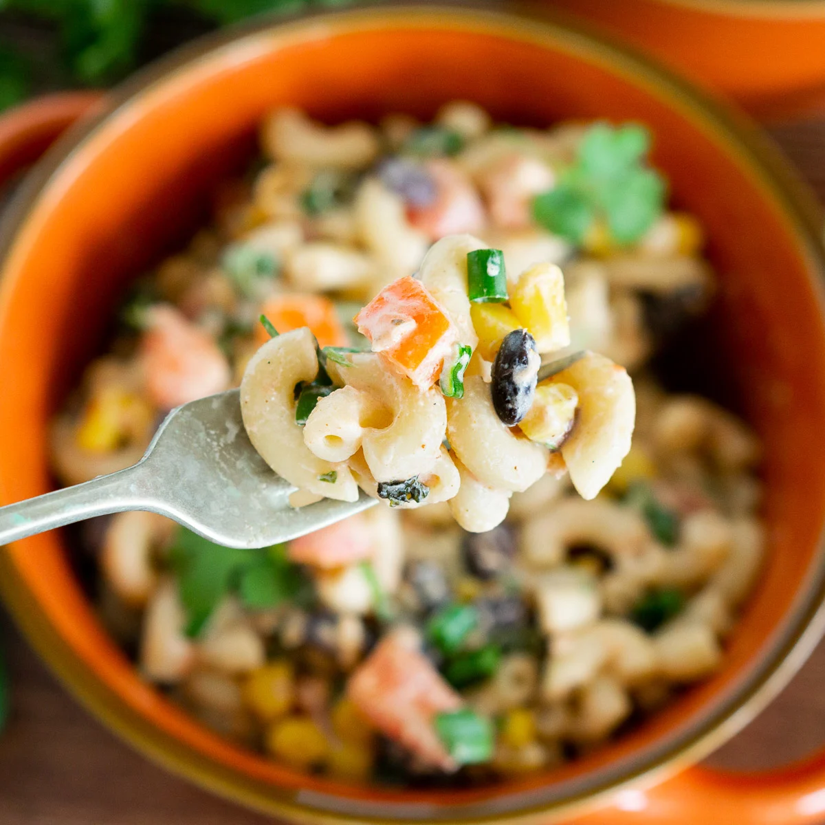 mexican macaroni salad with black beans on a fork