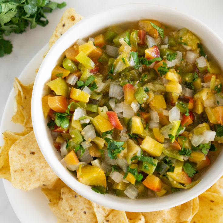 roasted peach tomatillo salsa in a bowl with tortilla chips