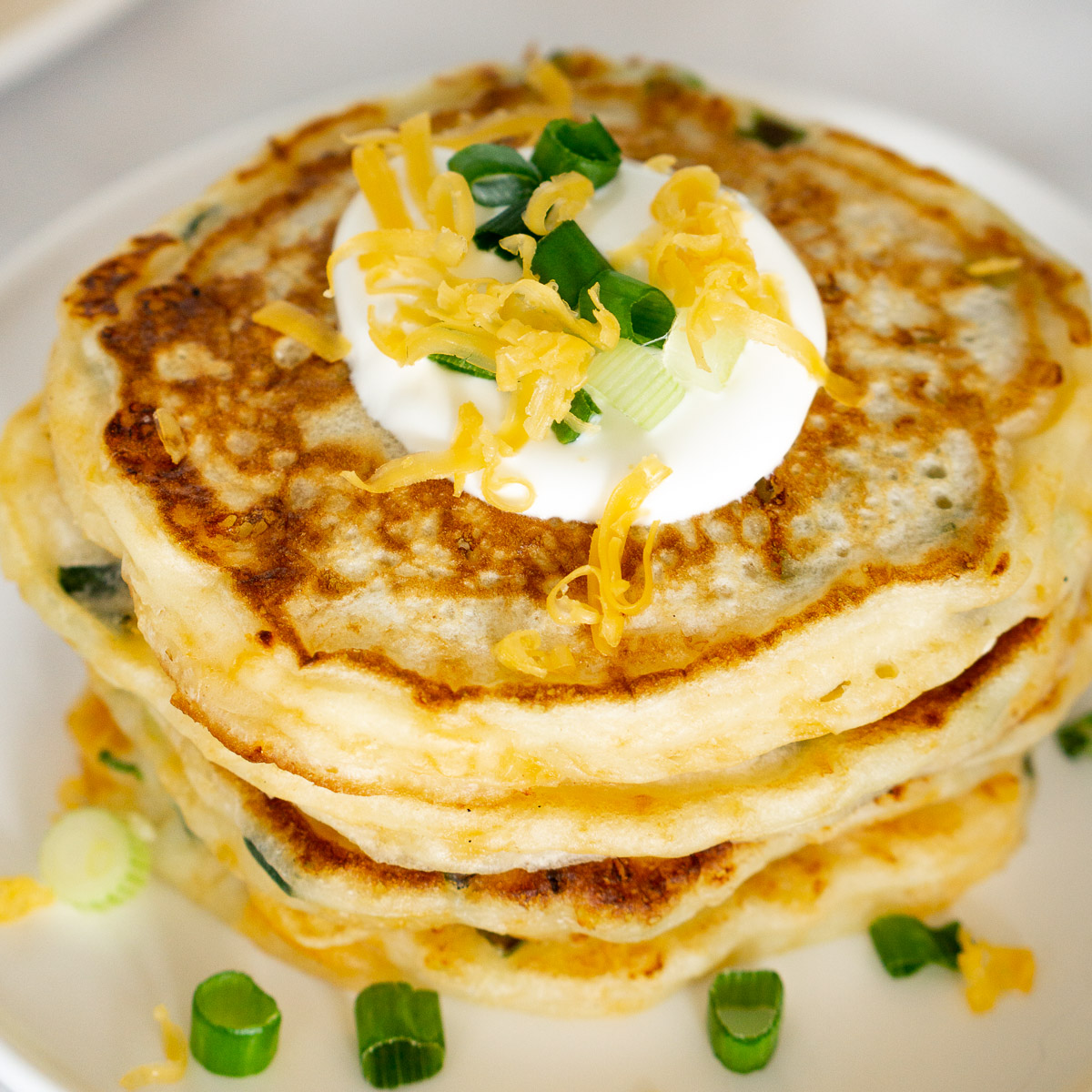 stack of savory pancakes with sour cream on top