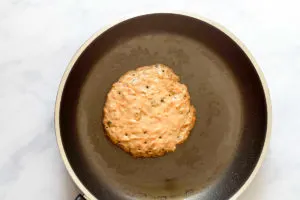 healthy carrot cake pancake cooking in a skillet