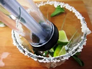 Mojito muddler muddling mint and limes in a glass