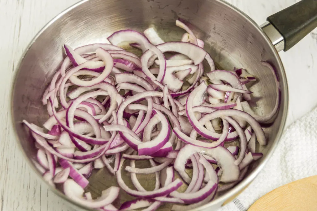 Sauteing sliced red onion.