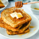 dripping honey onto a stack of pumpkin French toast