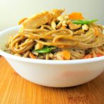 soba noodles with chicken, veggies, and peanut sauce in a bowl