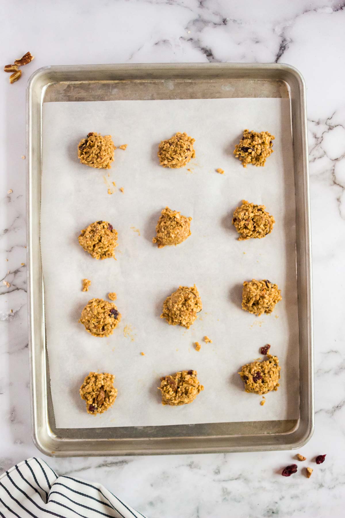 Scoops of oatmeal craisin cookie dough on a baking sheet