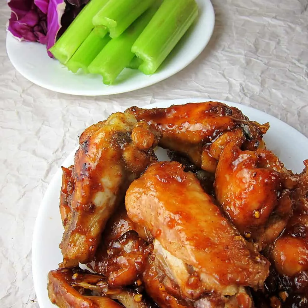 honey garlic ginger wings on a plate with celery in the background