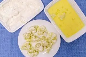 dipping cauliflower florets into the egg and flour mixture