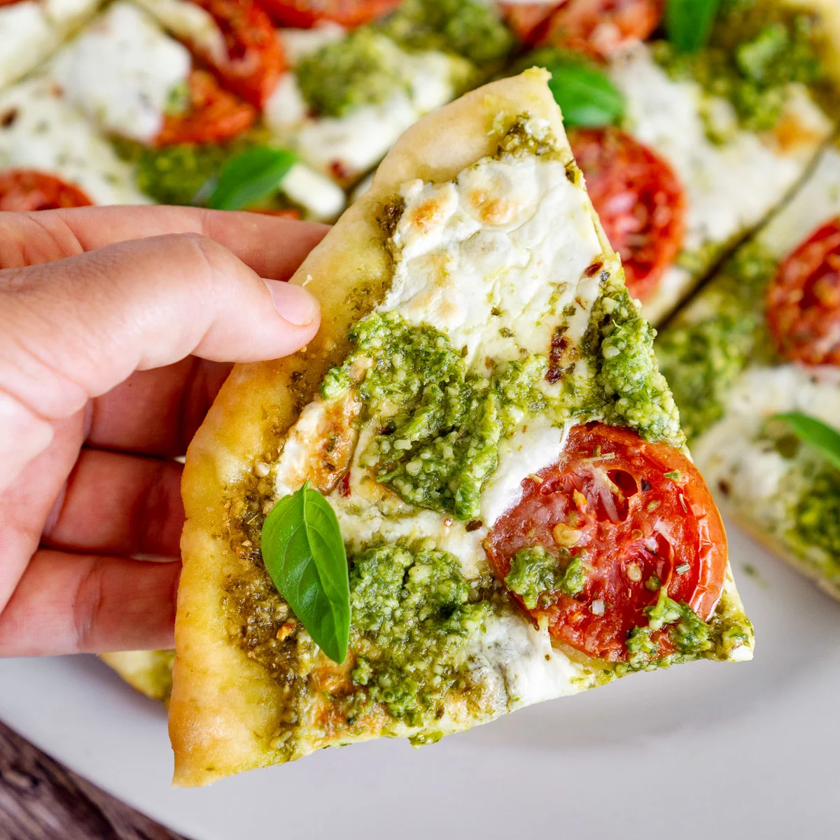 slice of pesto pizza made with 2 ingredient pizza dough