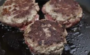 image of cooking venison burger patties on a skillet
