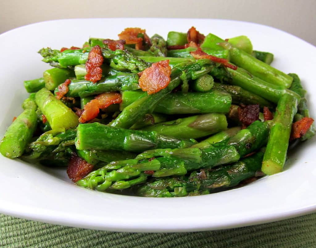 Plate of chopped pan fried asparagus with bacon.