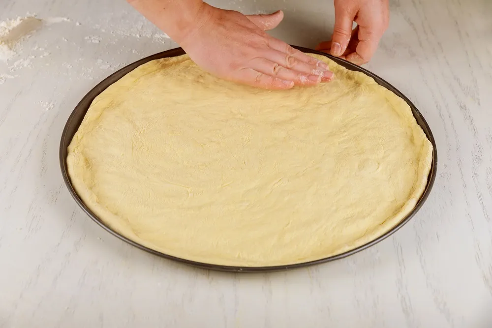 pressing dough into round pan