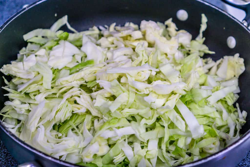 adding cabbage to the fried cabbage and kielbasa recipe