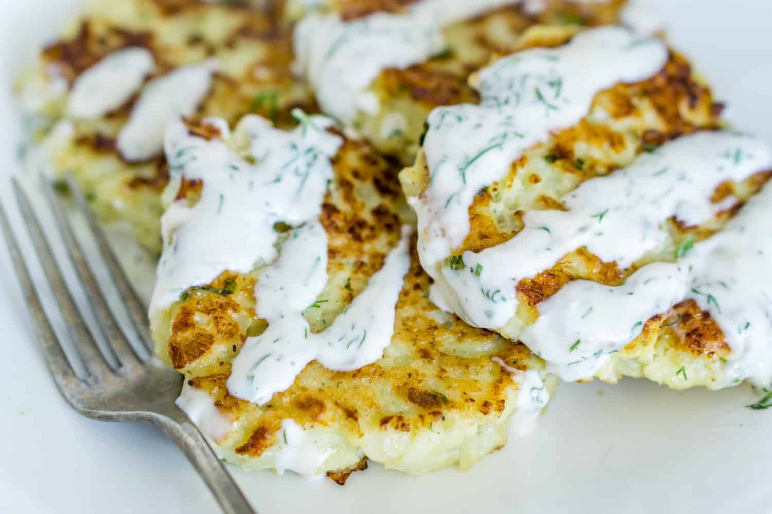 image of cauliflower fritters with garlic dill aioli on a plate