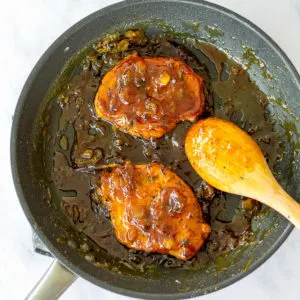 porkchops with pineapple sauce cooking in a pan