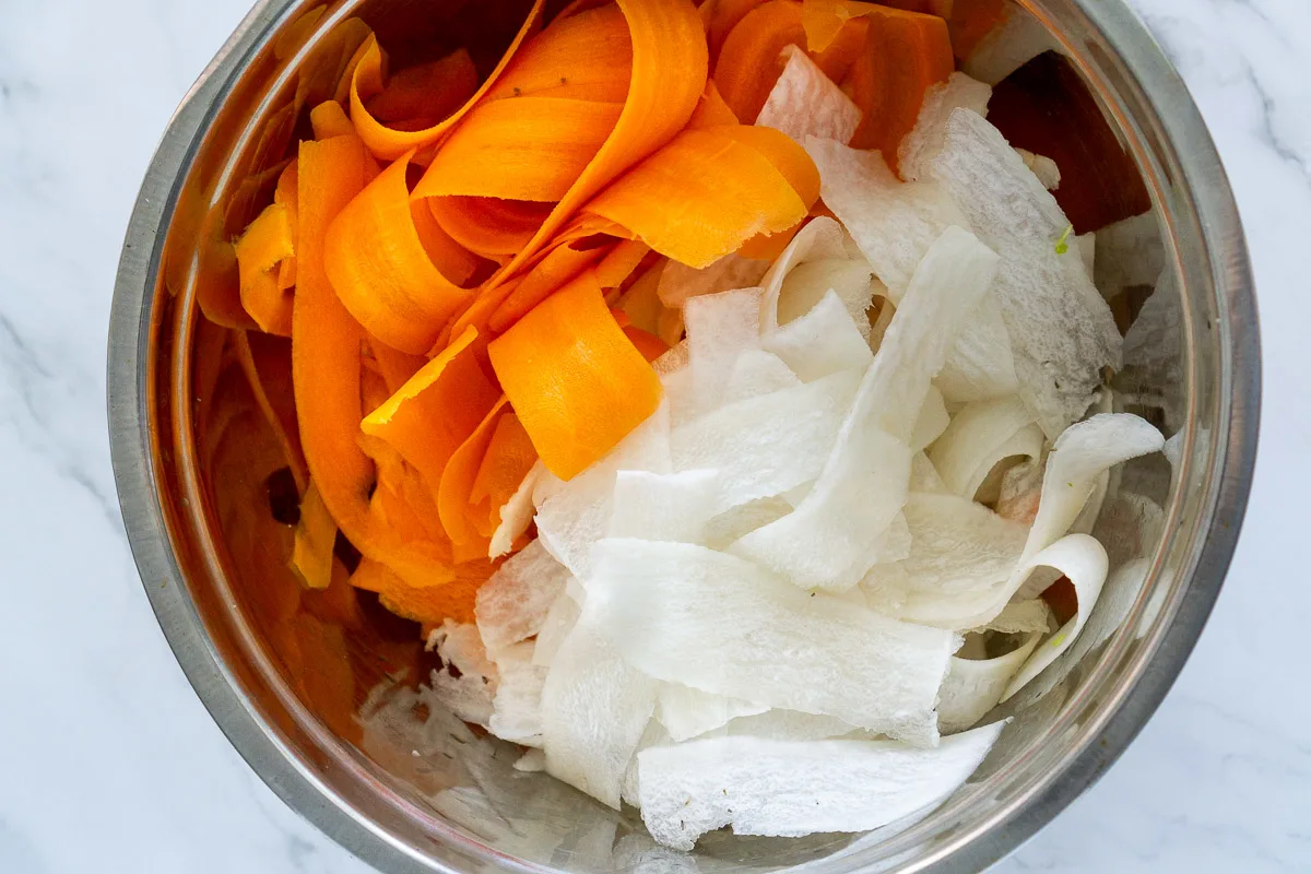 shaved carrot and shaved daikon radish in a bowl