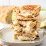 Stacked pear and goat cheese grilled cheese on a plate.
