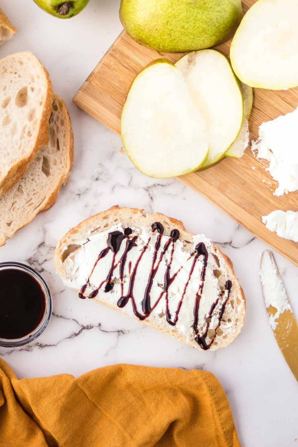 Goat cheese spread on bread and drizzled with balsamic glaze.