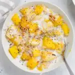 bowl of mango oatmeal with toasted coconut and chia seeds