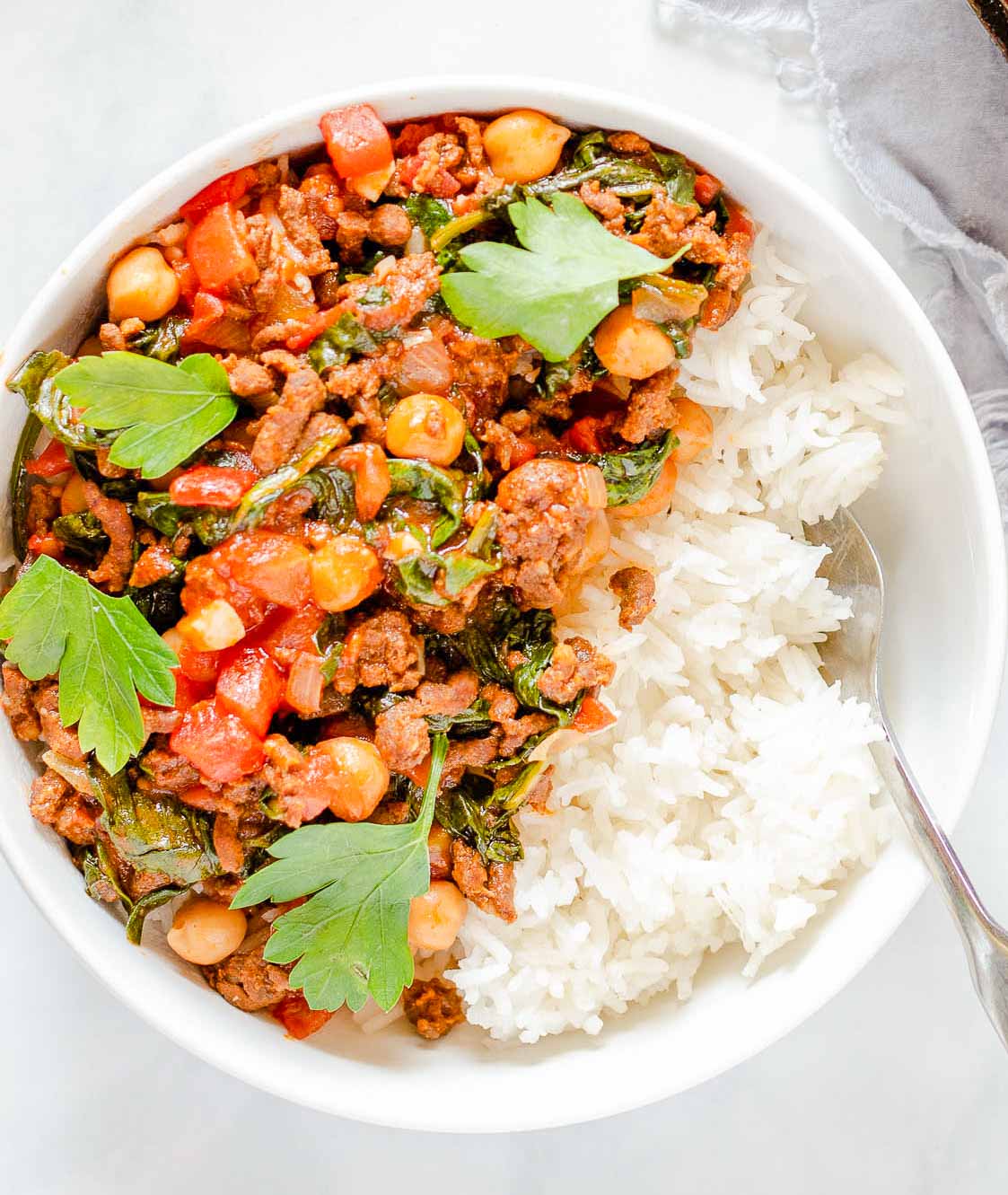 Chorizo chickpea stew over rice in a bowl.