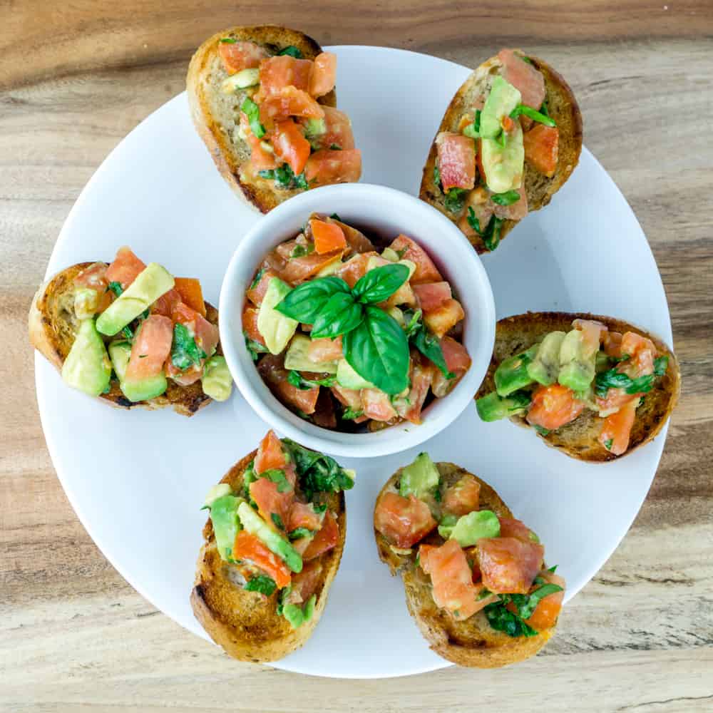 This Tomato Avocado Bruschetta is a delicious twist on the classic bruschetta. The creamy avocado pairs perfectly with the fresh tomatoes, basil, and parsley. Serve this over toasted baguettes for the perfect appetizer. From https://www.babaganosh.org