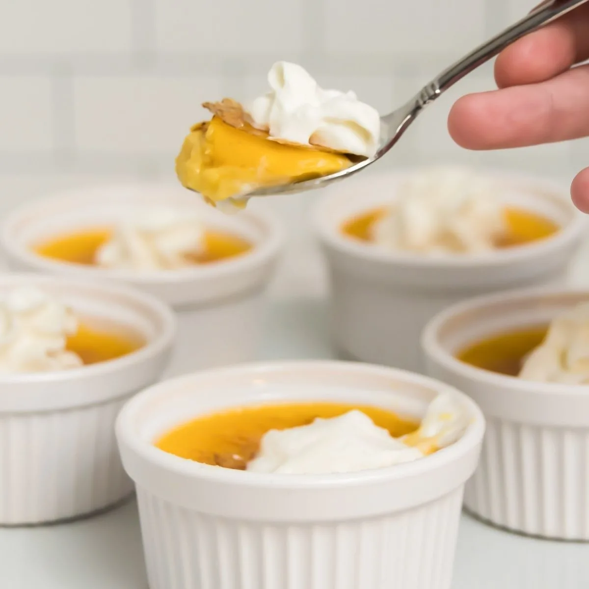 spoon holding creme brulee with whipped cream
