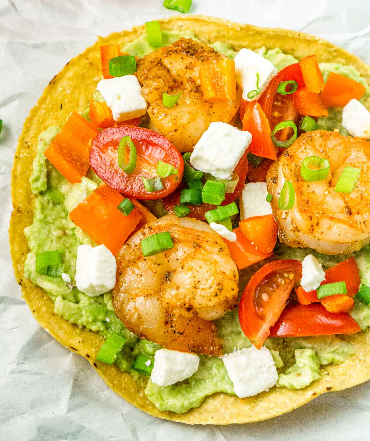 Overhead image of tostada with shrimp and guacamole