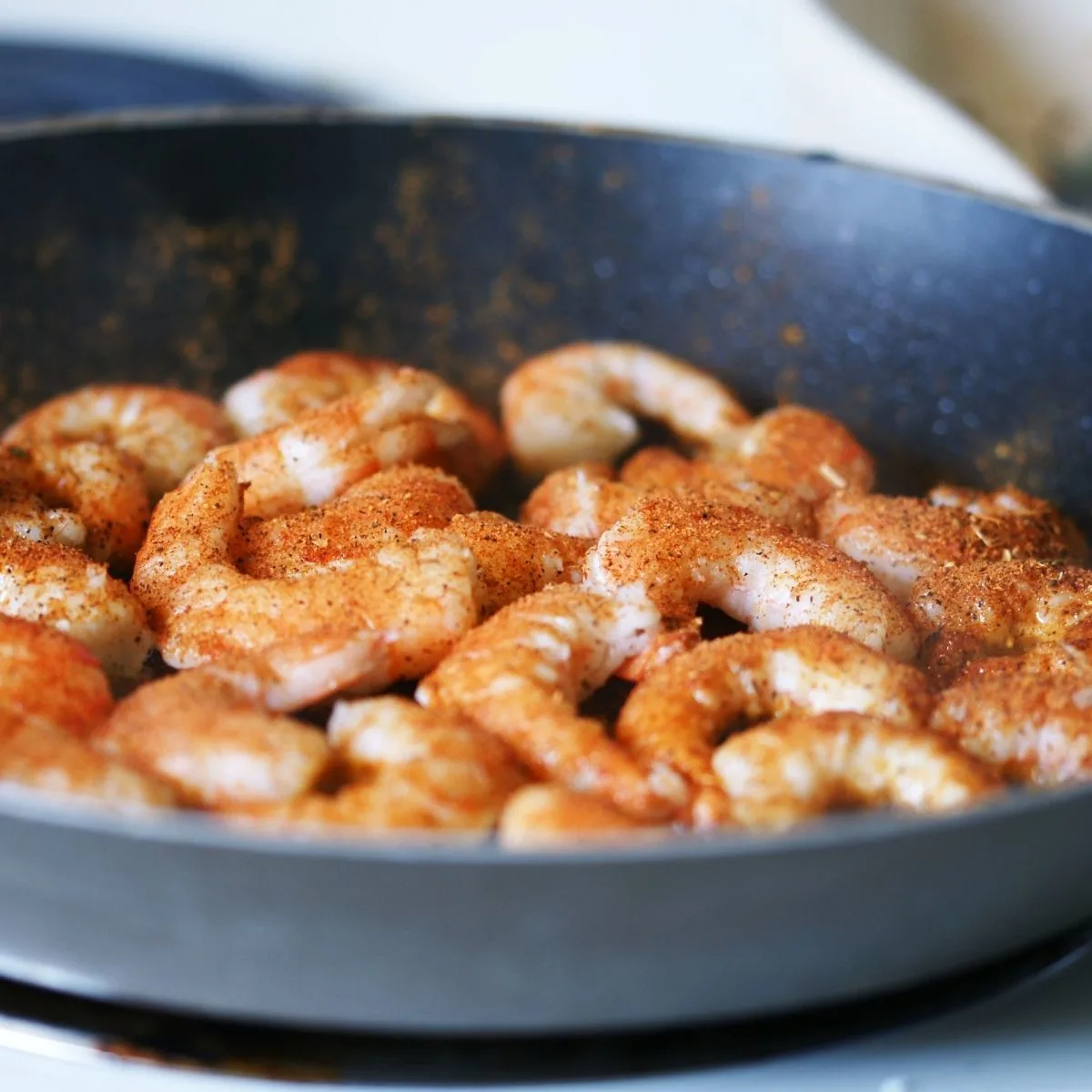 Shrimp seasoned with taco seasoning in a pan
