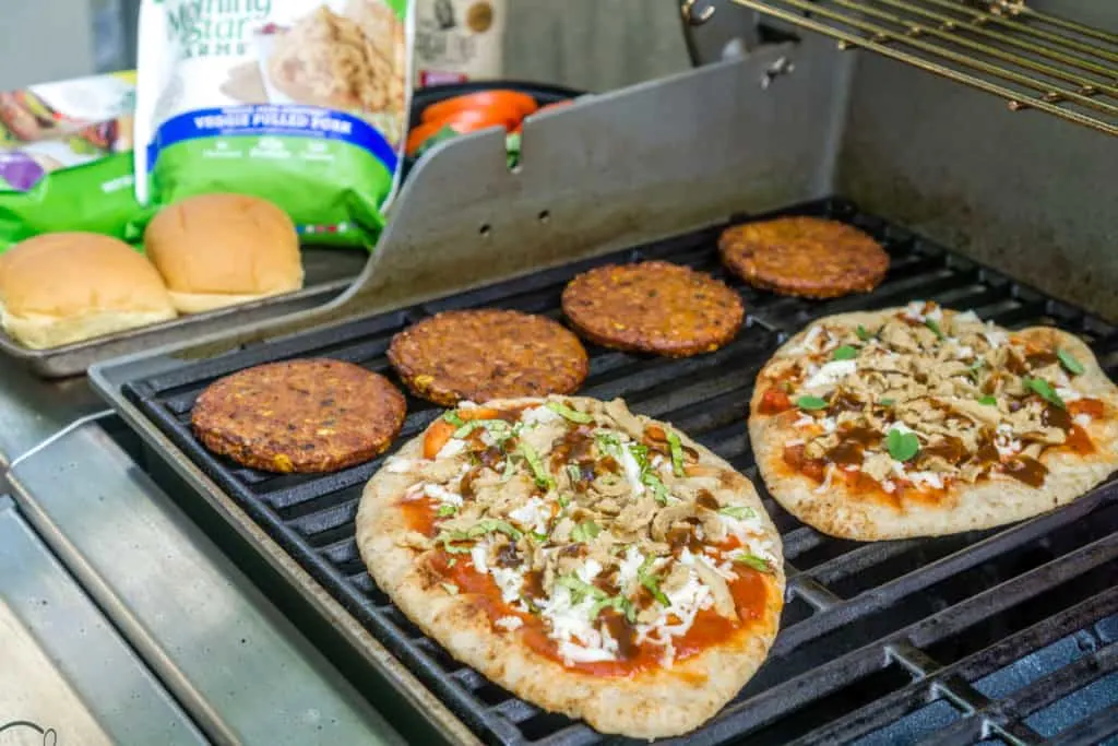grilled naan pizza and grilled veggie burgers on a grill