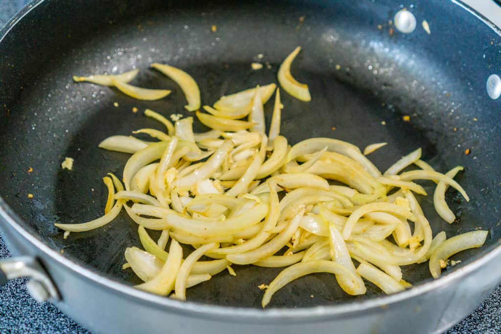 sliced onions cooking in a skillet