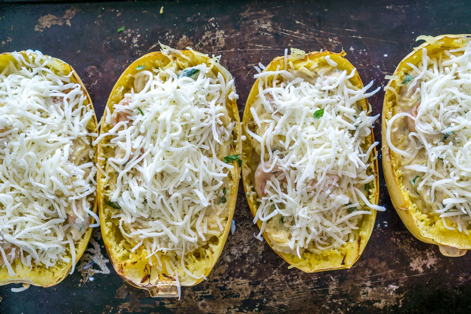 image of roasted spaghetti squash stuffed with shrimp topped with shredded cheese
