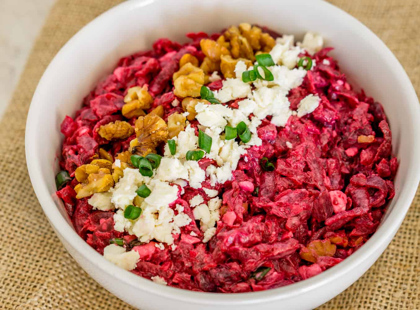 image of grated beet salad in a bowl with feta and walnuts