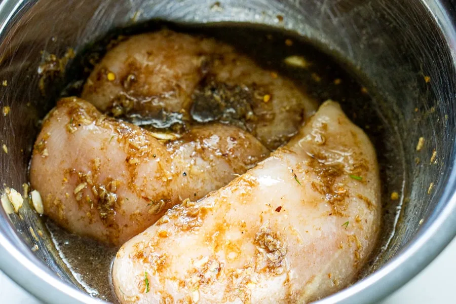 chicken breast marinating in a bowl