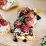 overhead shot of roasted grape crostini with blue cheese spread