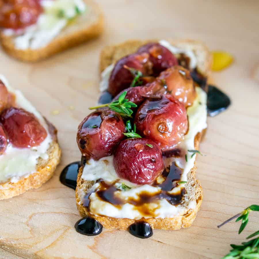 overhead shot of roasted grape crostini with blue cheese spread