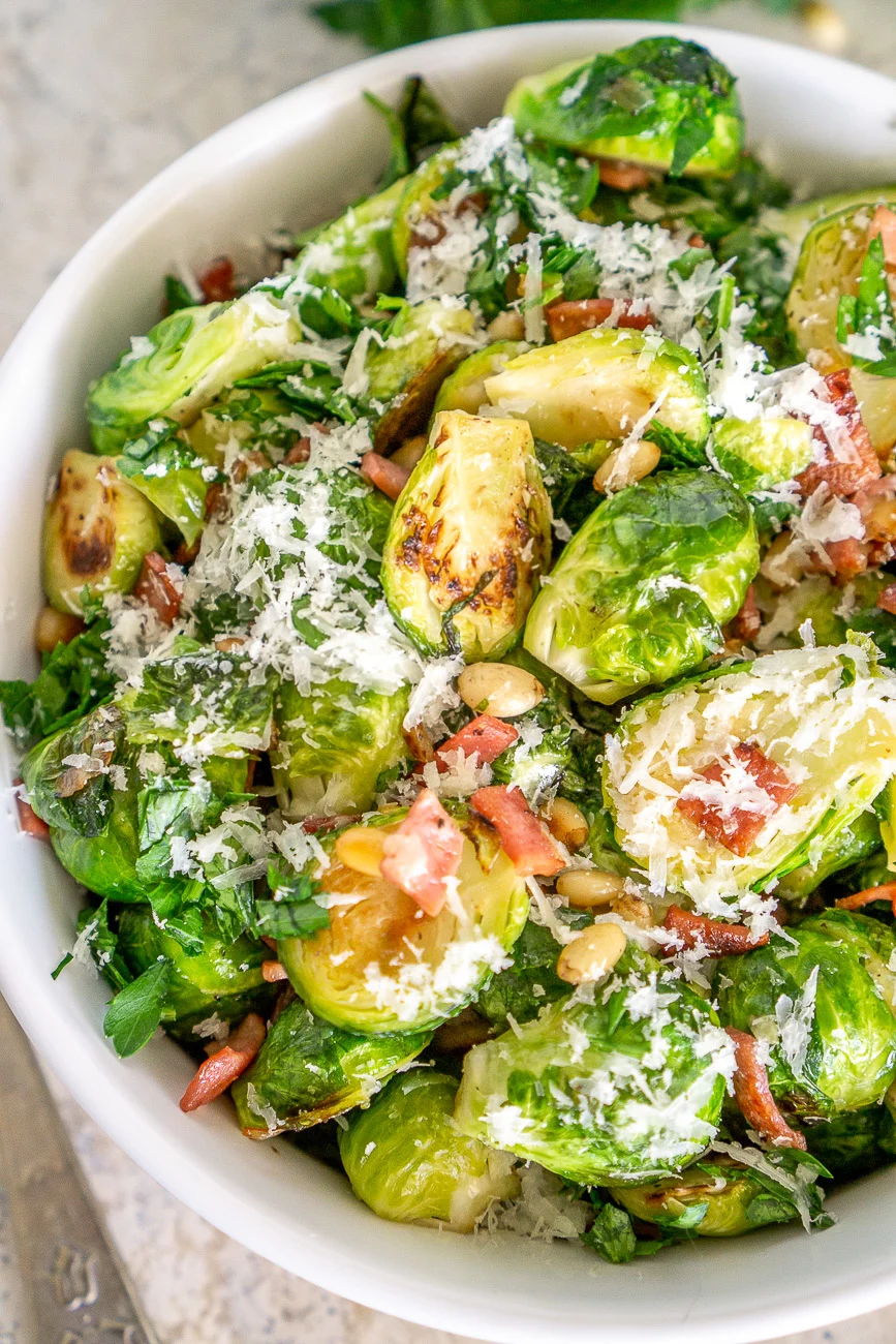 pan fried brussels sprouts with bacon and parmesan in a serving bowl