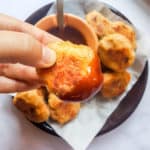 crispy chicken nugget dipped into sweet and sour sauce