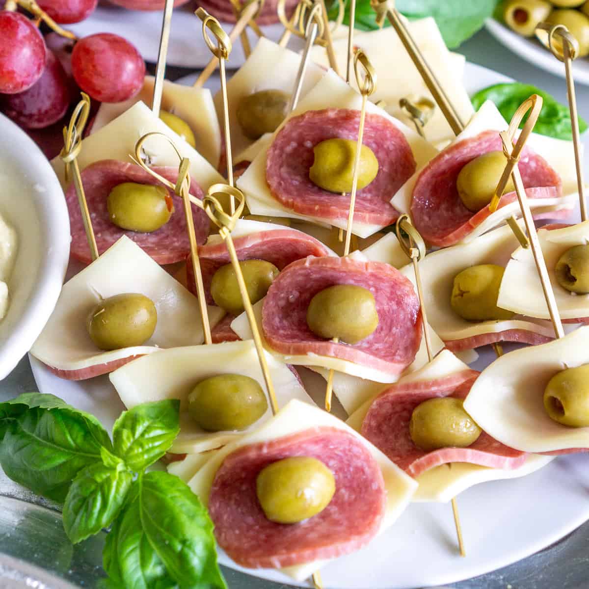 plate of salami wrapped around an olive and cheese - easy party appetizer