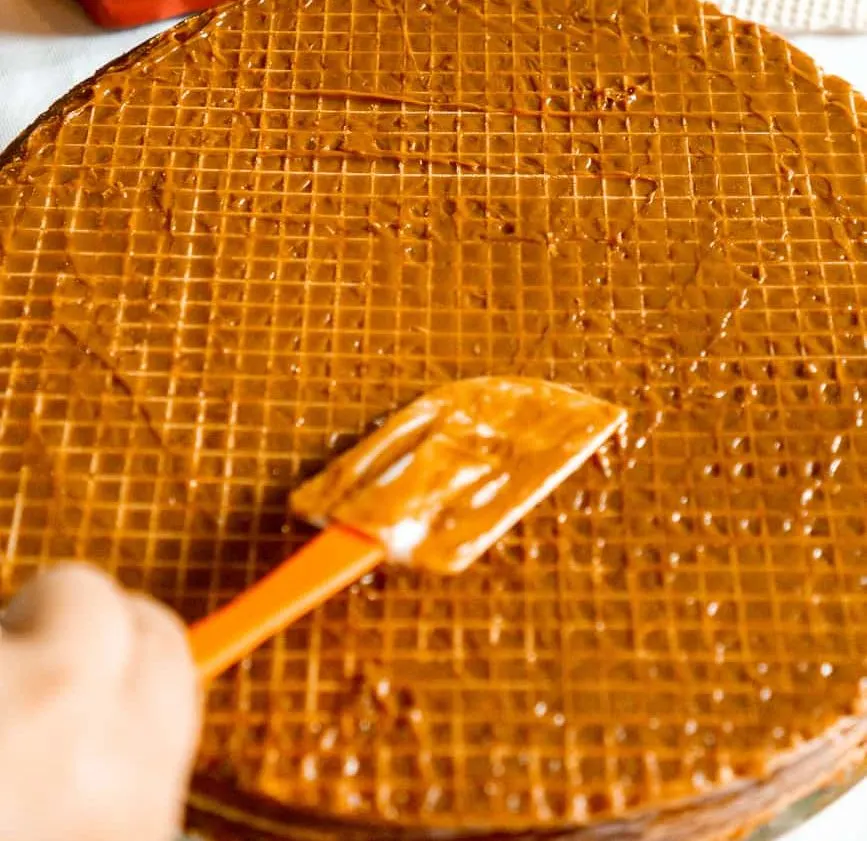 spreading dulce de leche on wafers with a spatula