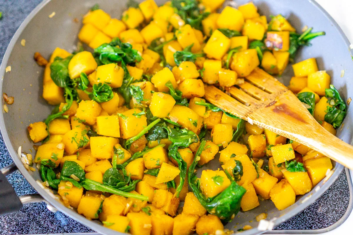butternut squash and spinach in a skillet