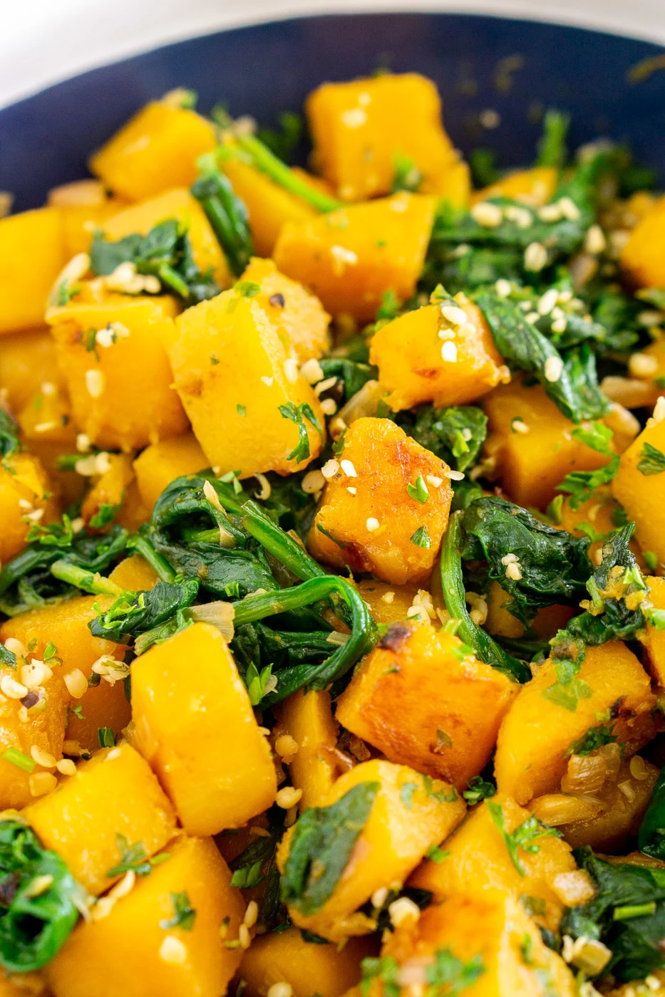 close up of cubed pan-fried butternut squash with spinach