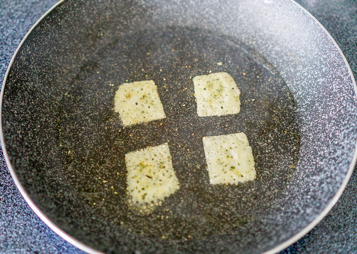 Making keto cheese crackers in a skillet.