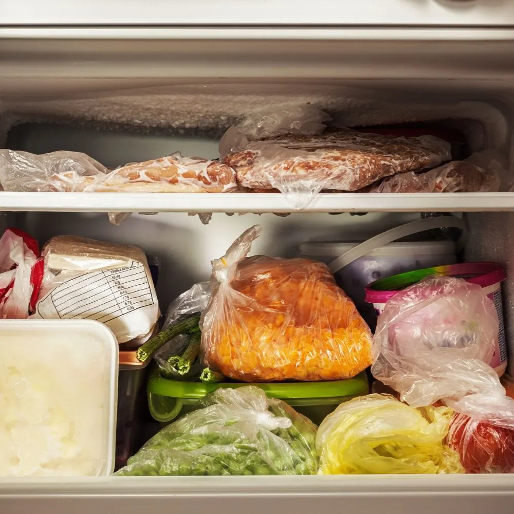 freezer filled with leftovers and frozen meat to save money