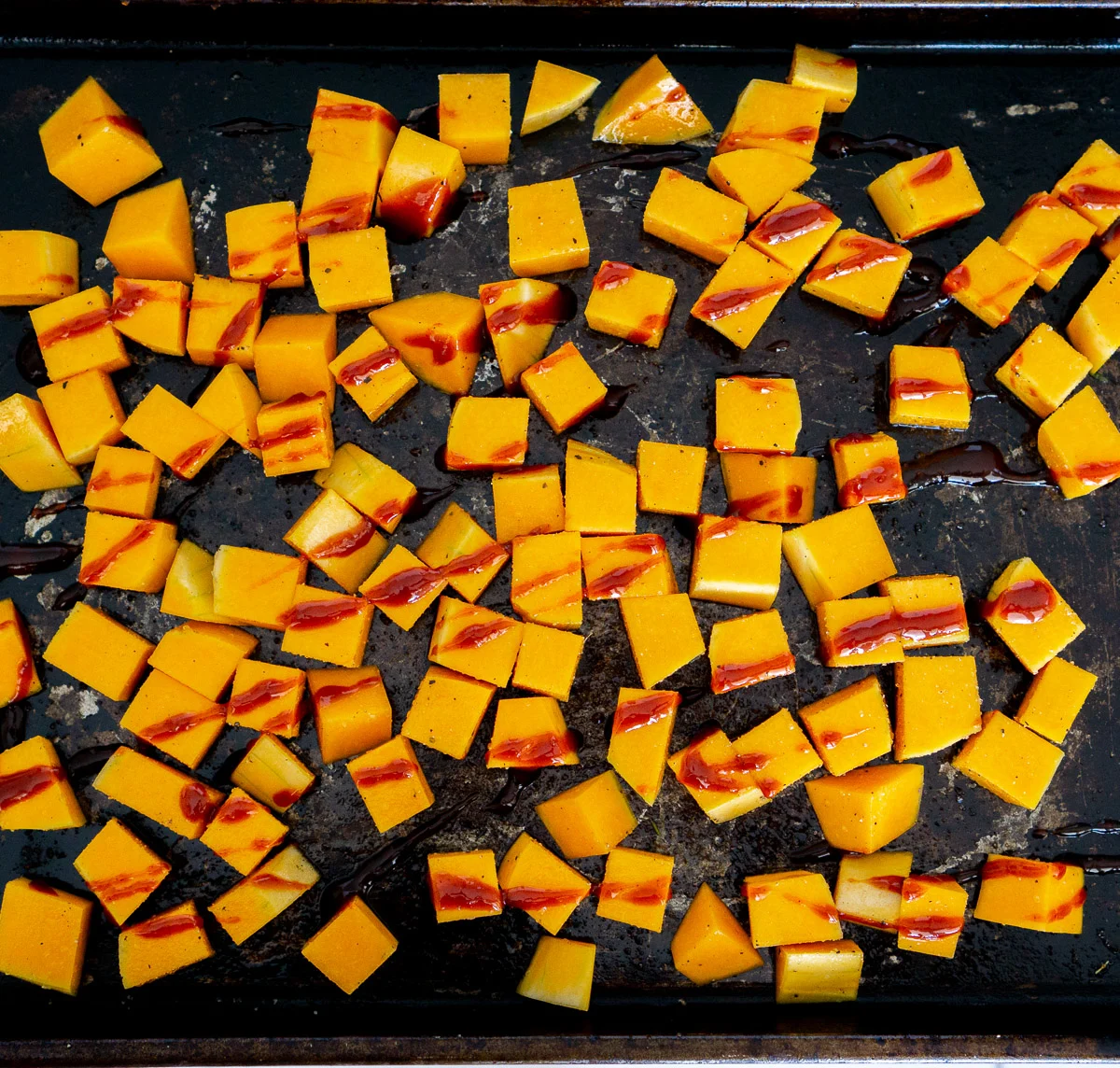 cubed butternut squash with gochujang sauce drizzled