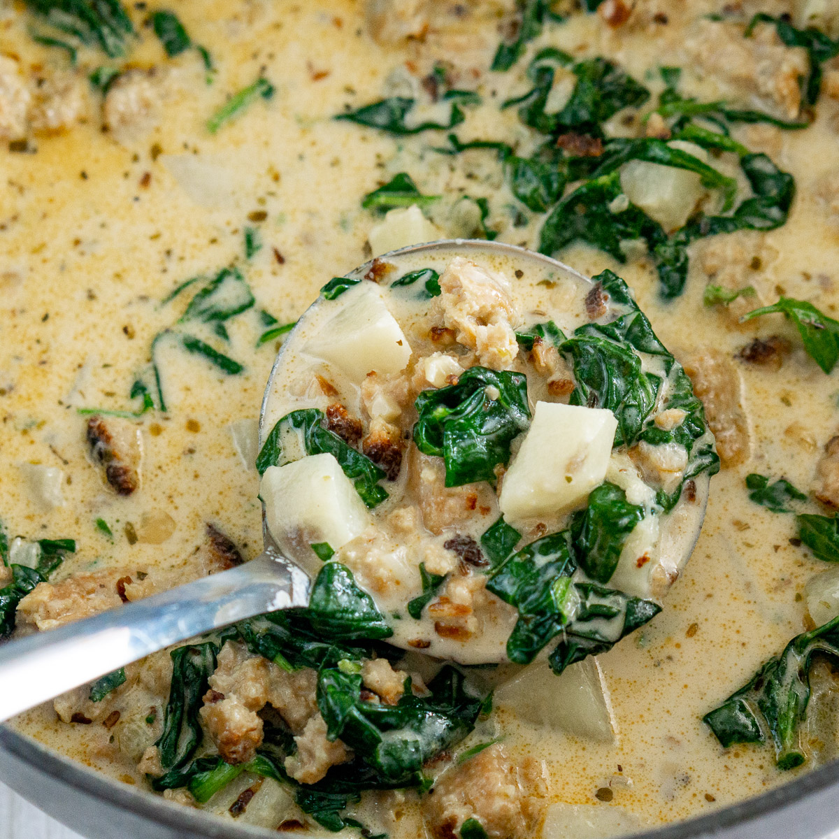 vegan zuppa toscana in a ladle
