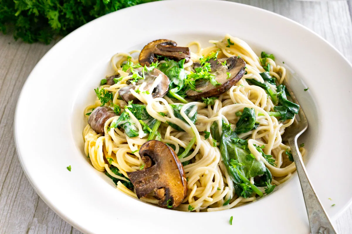 creamy mushroom pasta with spinach in a plate