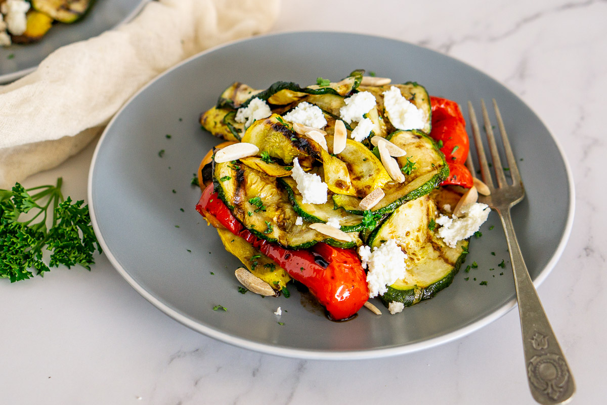 grilled summer squash salad on a plate with balsamic dressing